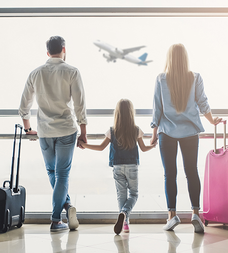 Famille à l'aéroport, les parents tenant leur enfant par la main en regardant un avion décoller
